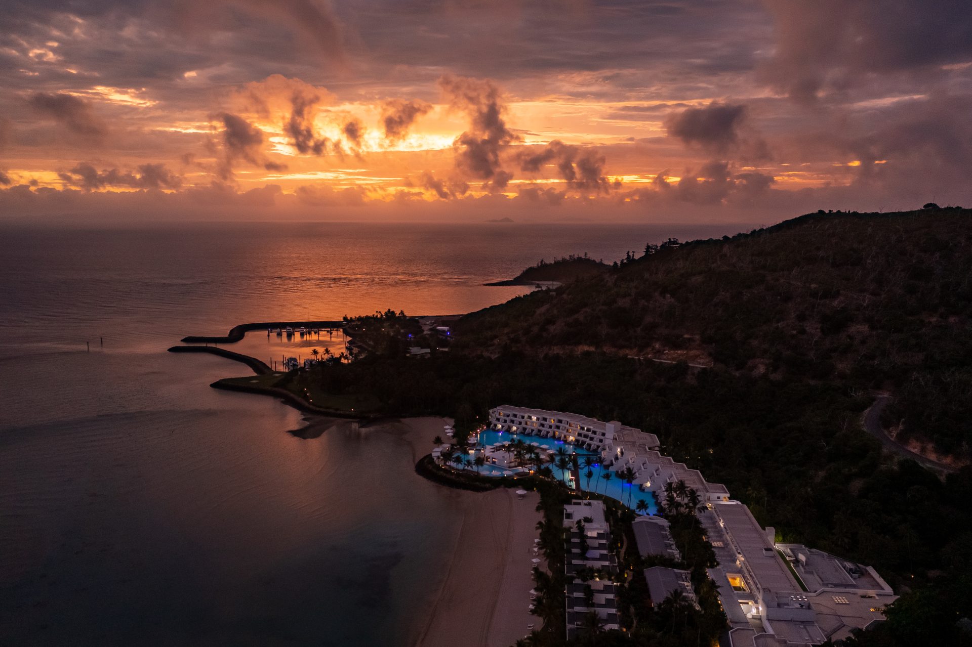 Golden sunset over Hayman Island beach with calm Whitsunday waters