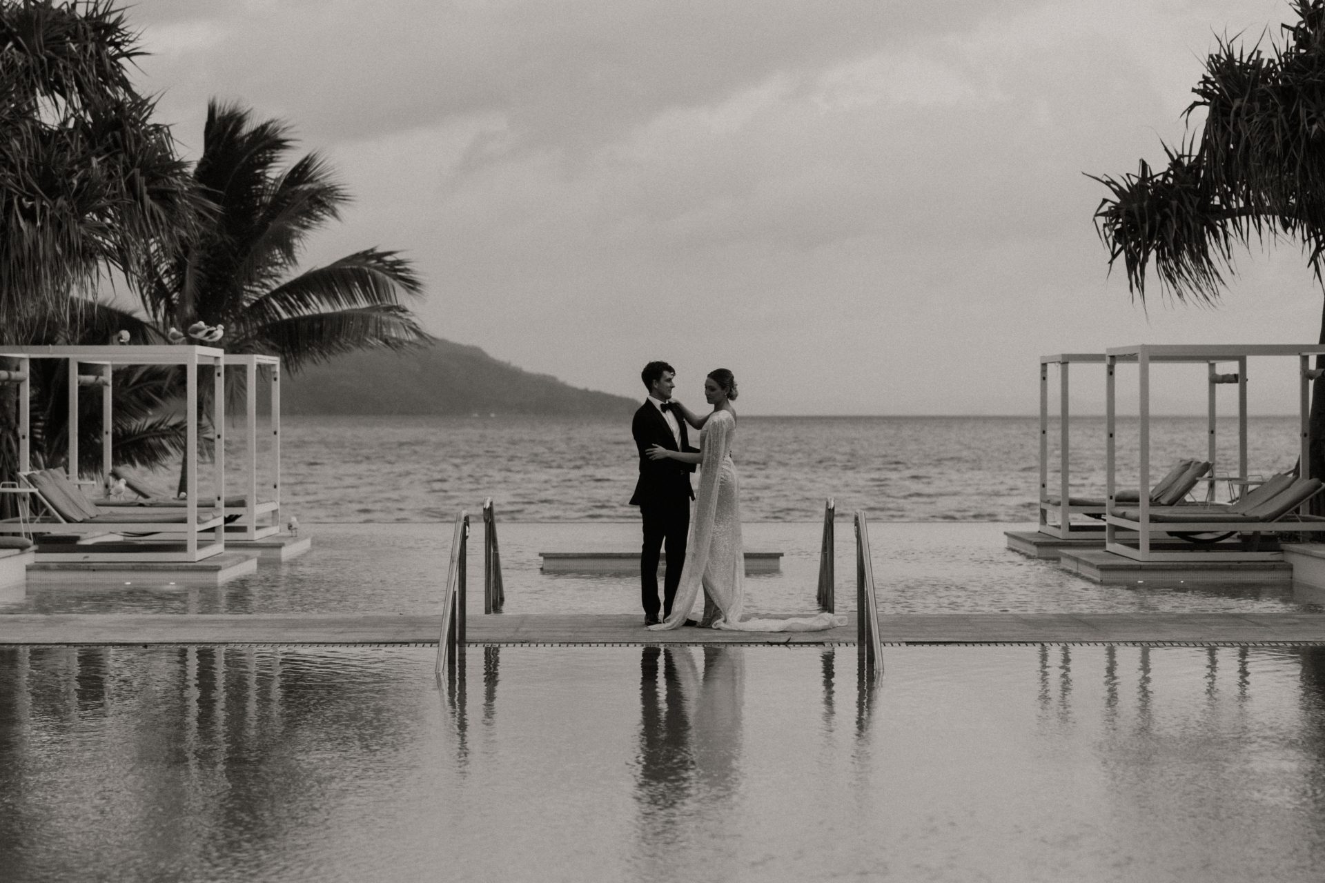 Newlywed couple walking hand in hand on Hayman Island beach after elopement ceremony
